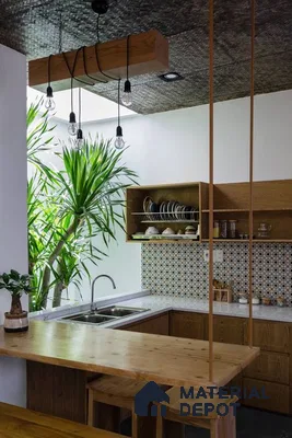 A kitchen with marble counter tops and wooden cabinetry, along with an island in the middle of the middle of the island with stairs leading to shop & more counter top space to an island in the middle of